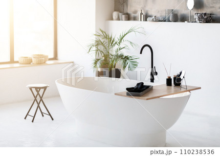 Spacious, modern bathroom interior featuring sleek freestanding bathtub Spacious, modern bathroom interior featuring sleek freestanding bathtub 110238536