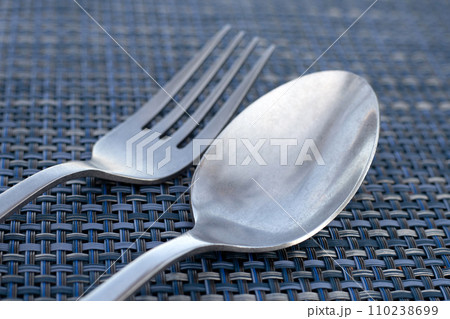 Spoon and fork on place mat Spoon and fork on place mat 110238699