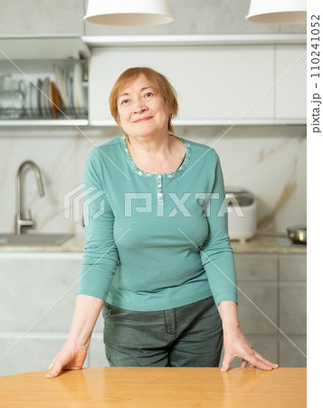 Adult woman in casual clothes posing in kitchen Adult woman in casual clothes posing in kitchen 110241052
