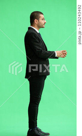 full-length portrait of a young man. standing isolated on green background 110243492