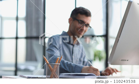 Serious and focused financier accountant on paper work inside office Serious and focused financier accountant on paper work inside office 110243538