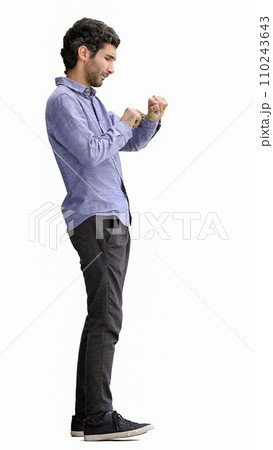 young man in full growth. isolated on white background looking at wristwatch young man in full growth. isolated on white background looking at wristwatch 110243643