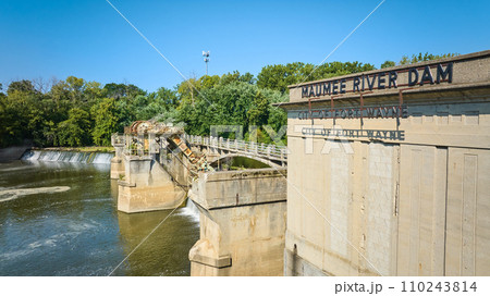 Sunny Maumee River Dam City of Fort Wayne sign on building with basin and waterfalls beneath green trees aerial Sunny Maumee River Dam City of Fort Wayne sign on building with basin and waterfalls beneath green trees aerial 110243814