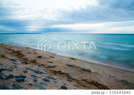 Serene Sunrise Over Lake Michigan's Rocky Blurred Beachscape Serene Sunrise Over Lake Michigan's Rocky Blurred Beachscape 110243840