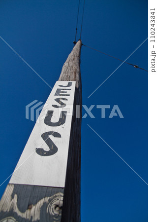Upward View of Jesus Lettering on Tall Utility Pole Against Clear Blue Sky Upward View of Jesus Lettering on Tall Utility Pole Against Clear Blue Sky 110243841