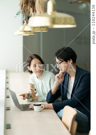 カフェで打ち合わせをする男女 110244136