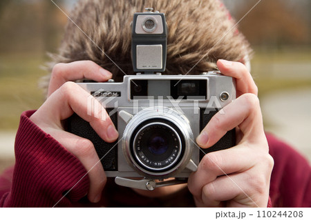 Female Photographer Capturing Winter Scenery with Vintage Film Camera 110244208