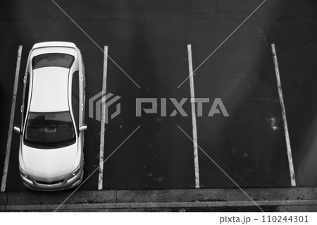 Minimalist Aerial View of Solitary Car in Empty Parking Lot Minimalist Aerial View of Solitary Car in Empty Parking Lot 110244301