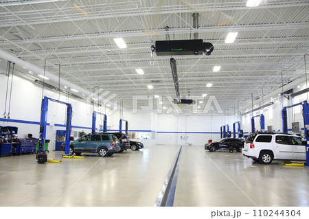 Modern Vehicle Service Center Interior with Blue Car Lifts Modern Vehicle Service Center Interior with Blue Car Lifts 110244304