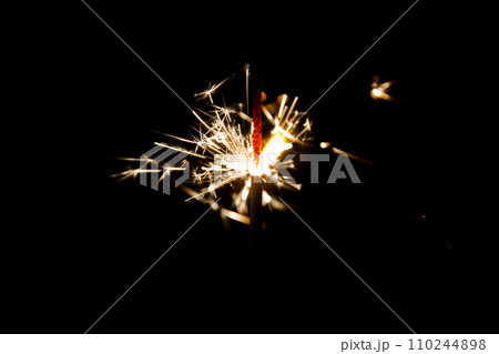 Luminous Sparkler in Motion Against Pitch-Black Background 110244898