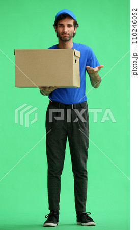full-length male courier holding a box on a green background full-length male courier holding a box on a green background 110246052