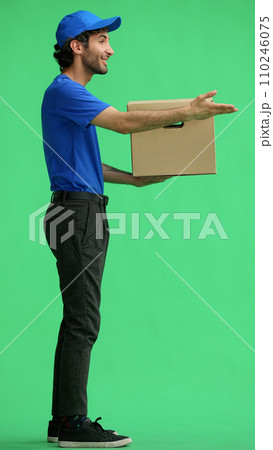 full-length male courier holding a box on a green background 110246075