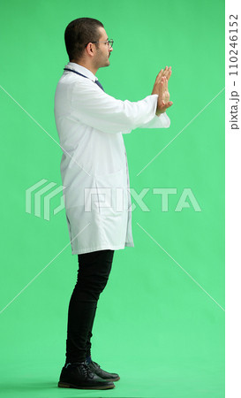 male doctor in a white coat on a green background shows a cancel sign male doctor in a white coat on a green background shows a cancel sign 110246152