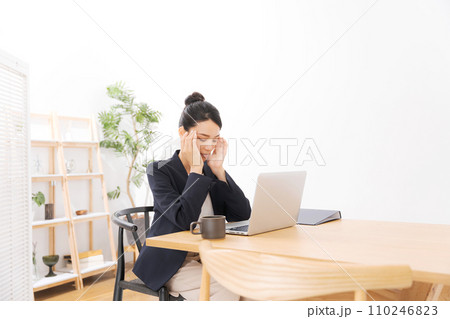頭を抑えるスーツ姿の20代女性 頭を抑えるスーツ姿の20代女性 110246823
