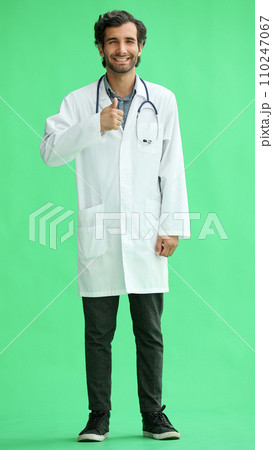 male doctor in a white coat on a green background showing thumbs up 110247067