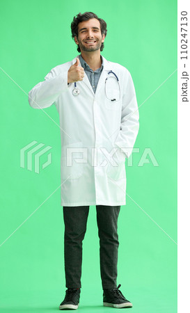 male doctor in a white coat on a green background shows a thumbs up sign male doctor in a white coat on a green background shows a thumbs up sign 110247130
