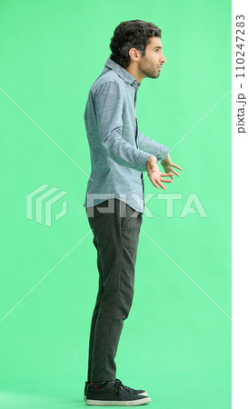 young man in full growth. isolated on green background profile 110247283