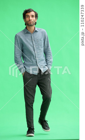 full-length portrait of a young man. standing isolated on green background full-length portrait of a young man. standing isolated on green background 110247339