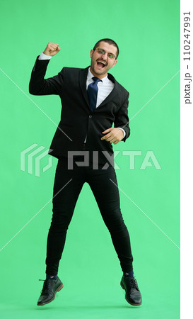 man in full growth. isolated on green background jumping rejoices man in full growth. isolated on green background jumping rejoices 110247991