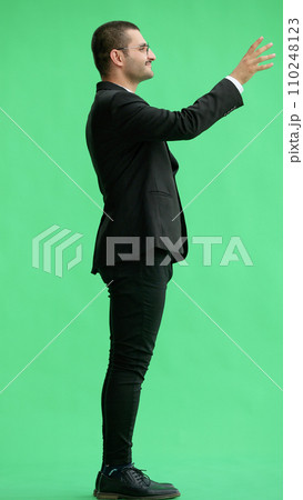 young man in full growth. isolated on green background pointing with finger 110248123