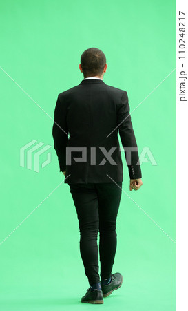 young man in full growth. isolated on green background. view from the back young man in full growth. isolated on green background. view from the back 110248217