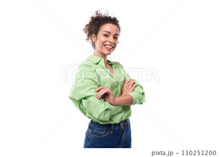 young positive brunette businesswoman with curly hair tied up in a ponytail in a light green shirt young positive brunette businesswoman with curly hair tied up in a ponytail in a light green shirt 110251200