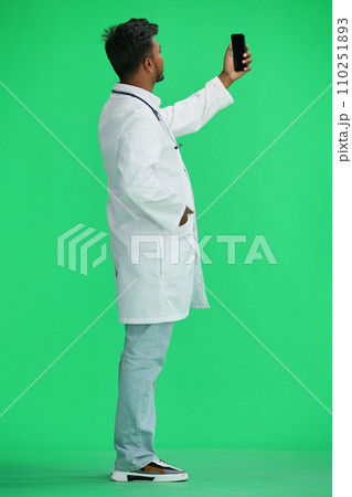 A male doctor, on a green background, in full height, talking on the phone, profile A male doctor, on a green background, in full height, talking on the phone, profile 110251893