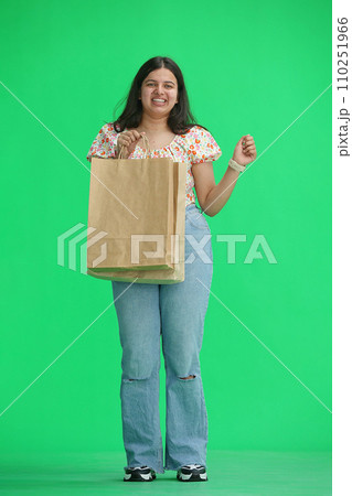 A woman, on a green background, with a package 110251966