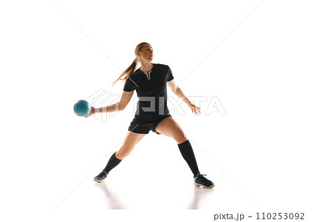 Concentrated female handball player perfecting her throw, highlighting strength and precision against white studio background. Concept of sport. 110253092