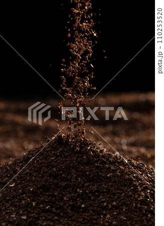 Ground Coffee roasted powder dust fly explosion, Coffee crushed ground float pouring. Roasted Coffee powder ground dust splash explosion in mid Air. Black background Isolated selective focus blur 110253520