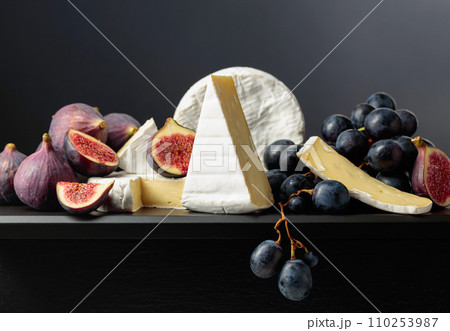 Camembert cheese with figs and grapes. 110253987