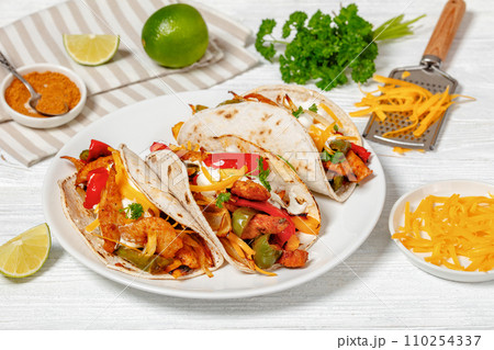 baked tex-mex chicken fajitas on a plate, top view baked tex-mex chicken fajitas on a plate, top view 110254337