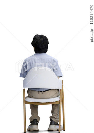 A guy in a blue shirt, on a white background, is sitting on a chair A guy in a blue shirt, on a white background, is sitting on a chair 110254470