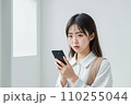 スマートフォンを手に持って怒り気味に驚く日本人美女 110255044
