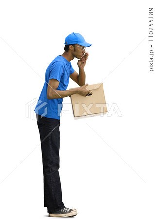 A male deliveryman, on a white background, full-length, with a box, tells a secret A male deliveryman, on a white background, full-length, with a box, tells a secret 110255189