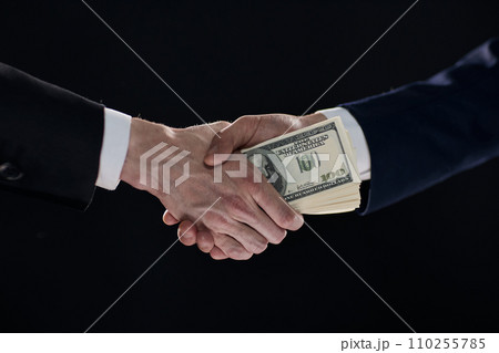Handshake with the transfer of money on a black background 110255785