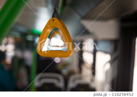 Yellow holder for grip on the bus on the handrail on the ceiling while riding while standing in public transport Yellow holder for grip on the bus on the handrail on the ceiling while riding while standing in public transport 110256452