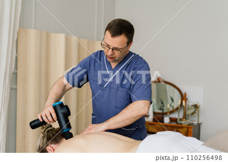 Young fat woman getting massage treatment in day spa cabinet. Young fat woman getting massage treatment in day spa cabinet. 110256498