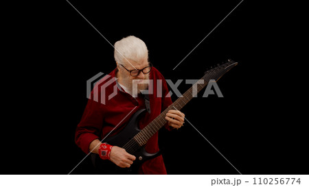 Contemporary senior man plays the electric guitar against a black background, showcasing his rockstar persona Contemporary senior man plays the electric guitar against a black background, showcasing his rockstar persona 110256774
