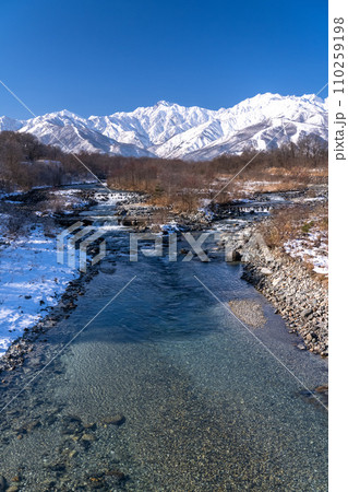 《長野県》雪景色の北アルプスと松川の清流・冬の白馬村 《長野県》雪景色の北アルプスと松川の清流・冬の白馬村 110259198