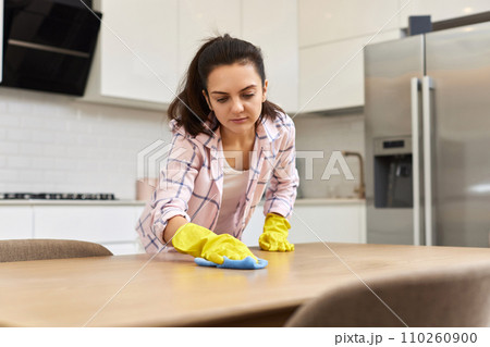 young woman cleaning wooden table with microfiber cloth. chores at home. Housekeeping young woman cleaning wooden table with microfiber cloth. chores at home. Housekeeping 110260900