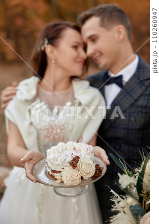 bride and groom on the nature in autumn . wedding couple with cake outdoor 110260947