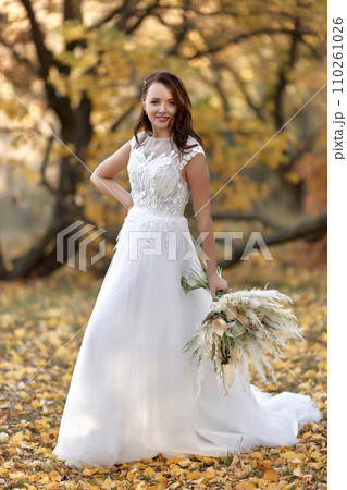beautiful happy bride holding wedding autumn bouquet in nature 110261026