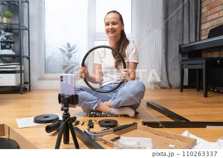 A girl shows furniture details via video link using the camera of her smartphone 110263337