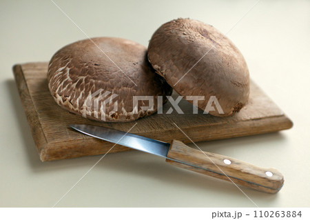 portobello mushrooms on wooden table. brown mushrooms, on a dark table with cutting board. Selective focus. portobello mushrooms on wooden table. brown mushrooms, on a dark table with cutting board. Selective focus. 110263884