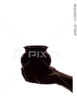 Hand young man holds ceramic pot - silhouette, concept Hand young man holds ceramic pot - silhouette, concept 110264586