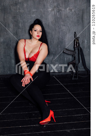 Woman in a dark room with her hands tied Woman in a dark room with her hands tied 110265619