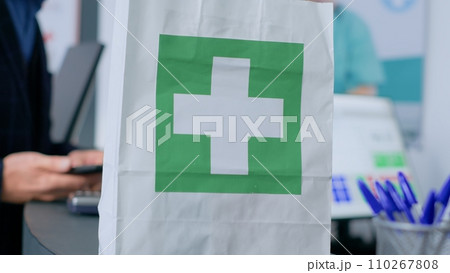 Shopper at drugstore counter, showing worker prescribed heart specialist prescribed pills, ready to buy them. Pharmacist assisting client with required pain treatment tablets, close up Shopper at drugstore counter, showing worker prescribed heart specialist prescribed pills, ready to buy them. Pharmacist assisting client with required pain treatment tablets, close up 110267808