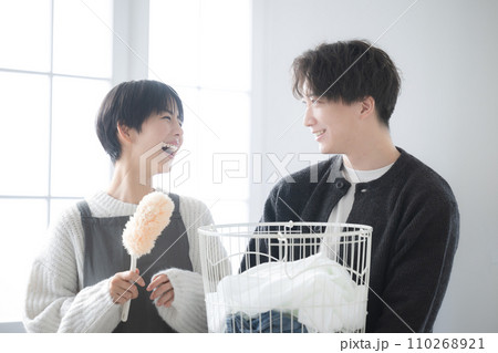 逆光の中、共働きの家事を一緒にする夫婦やカップルの上半身　見つめ合う仲良し クローズアップ	 110268921