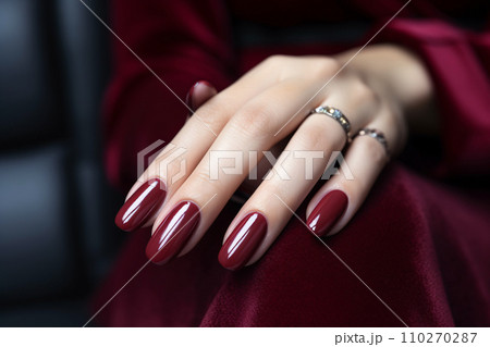 Woman hand with burgundy color nail polish on her fingernails. Burgundy nail manicure with gel polish at luxury beauty salon. Nail art and design. Female hand model. French manicure. Generative AI. 110270287